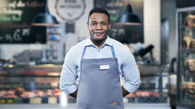 Ein Metzger steht vor der Fleischtheke